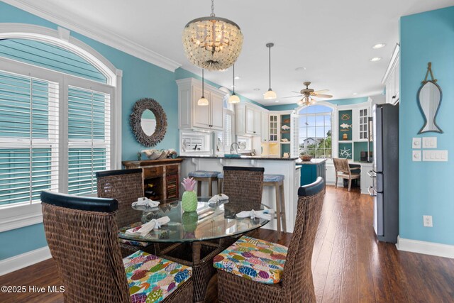57 Craven St, Ocean Isle Beach, NC 28469 - dining room with a ceiling fan, dark wood finished floors, crown molding, a chandelier, and recessed lighting
