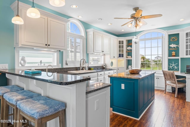 57 Craven St, Ocean Isle Beach, NC 28469 - kitchen with a center island, white cabinetry, a ceiling fan, a breakfast bar area, and recessed lighting