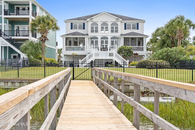 57 Craven St, Ocean Isle Beach, NC 28469 - dock with stairway, a fenced front yard, and a gate
