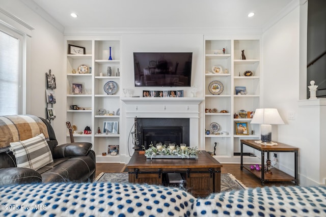 living room featuring crown molding, dark wood-type flooring, and built in shelves