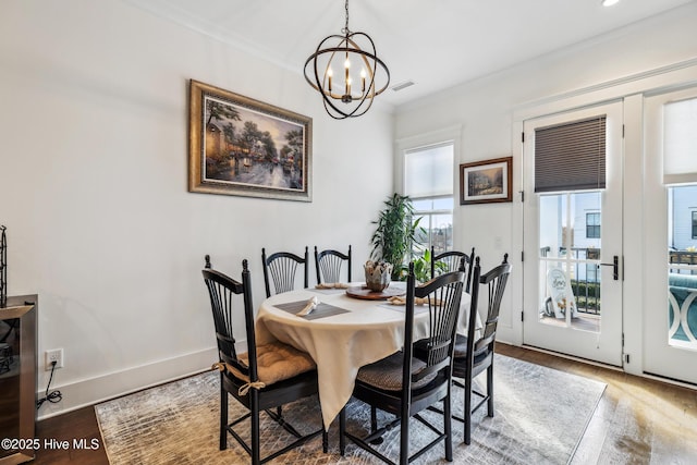 dining room featuring an inviting chandelier, ornamental molding, and hardwood / wood-style flooring