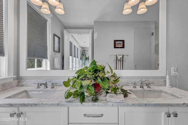 bathroom featuring an inviting chandelier, vanity, and a shower with shower door