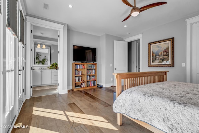 bedroom with ceiling fan, connected bathroom, and dark hardwood / wood-style flooring