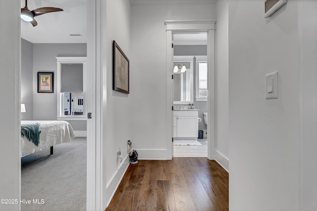 corridor with hardwood / wood-style flooring and sink