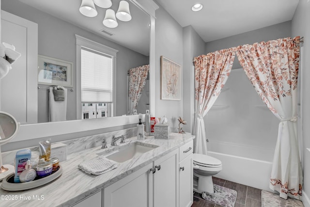 full bathroom with vanity, shower / tub combo, and toilet