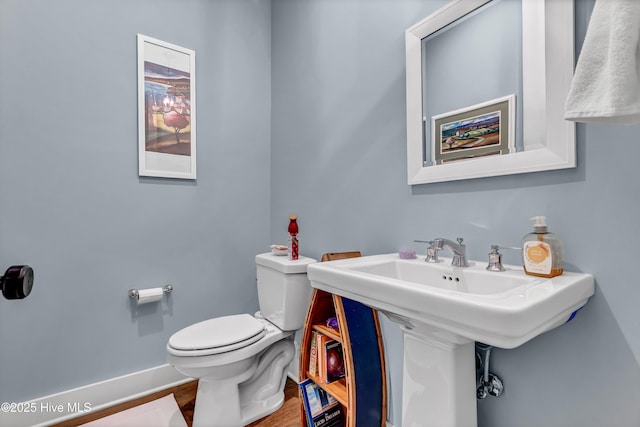 bathroom with hardwood / wood-style flooring, sink, and toilet