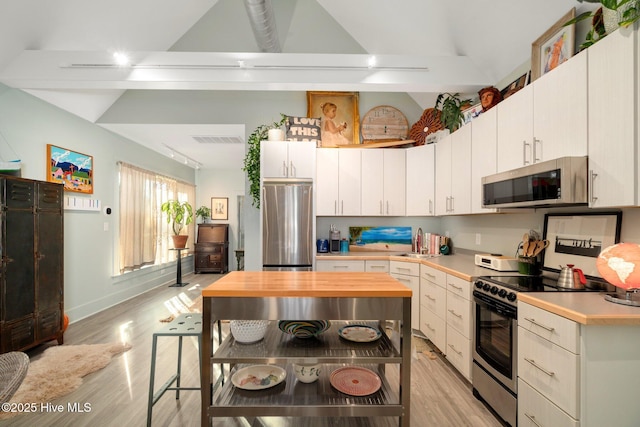 530 Contentnea Ave, New Bern, NC 28560 - kitchen featuring appliances with stainless steel finishes, a sink, light wood-style floors, vaulted ceiling, and wood counters