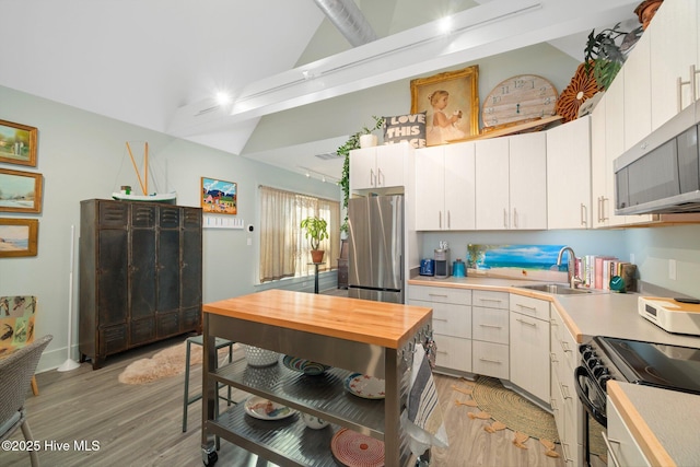 530 Contentnea Ave, New Bern, NC 28560 - kitchen with appliances with stainless steel finishes, light wood-style flooring, a sink, high vaulted ceiling, and white cabinets