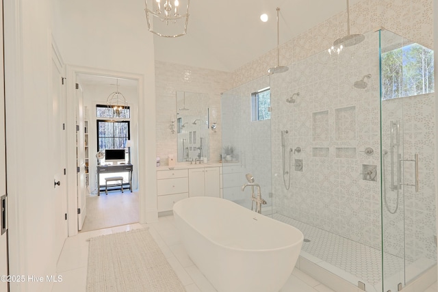 bathroom with a stall shower, a freestanding bath, and a notable chandelier