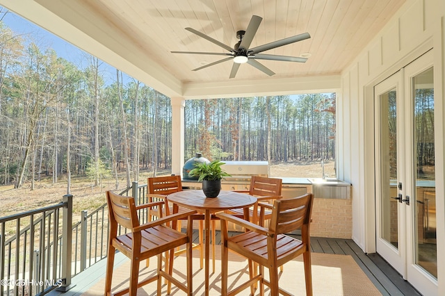 sunroom featuring a ceiling fan, wood ceiling, and french doors