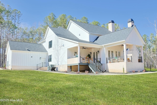 rear view of property with central air condition unit, ceiling fan, stairs, and a yard