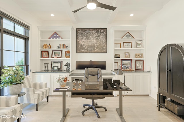 home office with light wood-style flooring, built in shelves, coffered ceiling, and a wealth of natural light