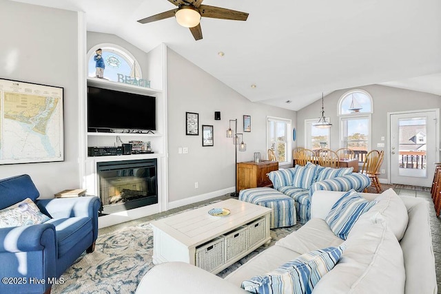 living room with ceiling fan, vaulted ceiling, and a wealth of natural light