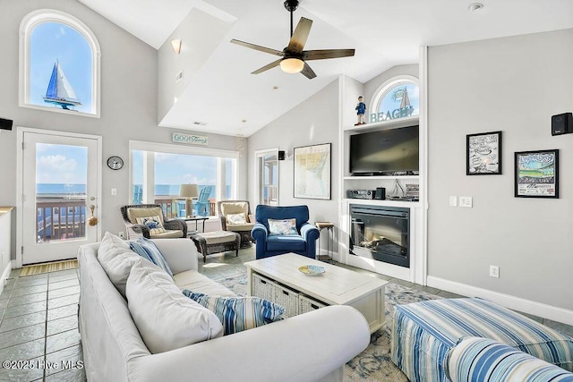 living room with ceiling fan, built in features, high vaulted ceiling, and a healthy amount of sunlight