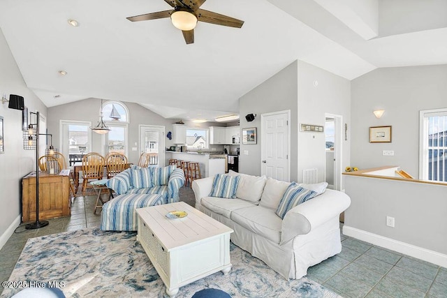 living room featuring lofted ceiling, ceiling fan, and light tile patterned floors