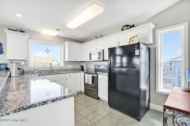 kitchen featuring appliances with stainless steel finishes, light stone counters, light tile patterned flooring, sink, and white cabinetry