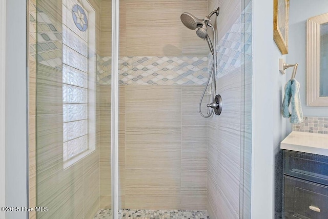 bathroom with vanity and tiled shower