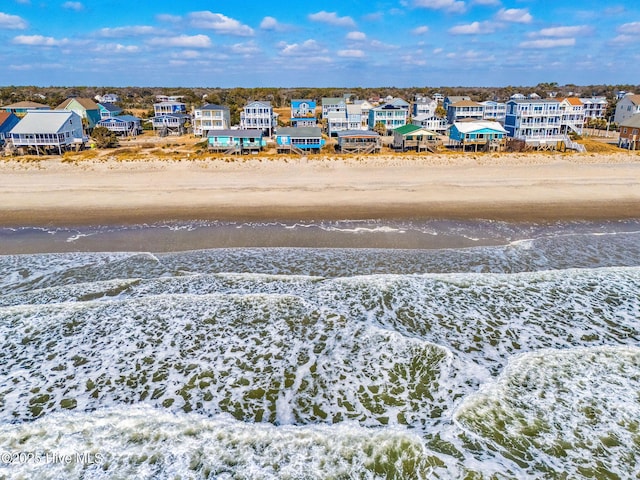 drone / aerial view featuring a water view and a view of the beach