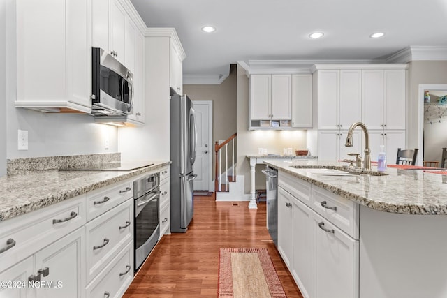 kitchen with white cabinetry, sink, ornamental molding, stainless steel appliances, and light stone countertops