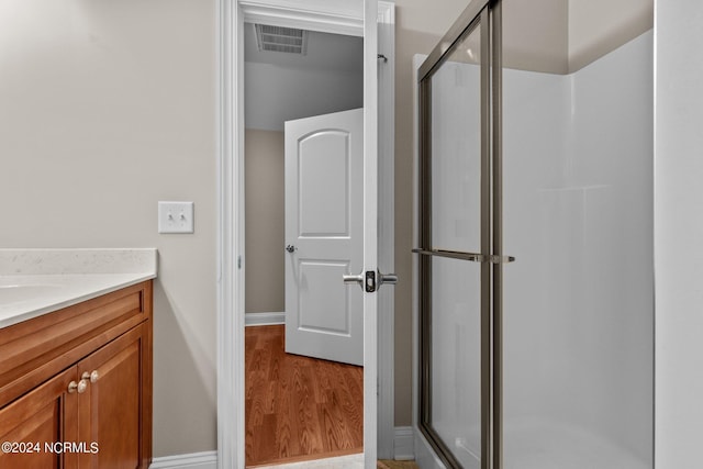 bathroom with vanity, wood-type flooring, and a shower with door