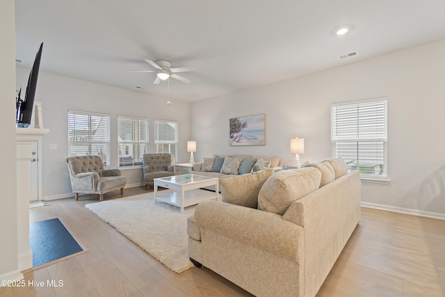 living room featuring ceiling fan, a healthy amount of sunlight, and light wood-type flooring