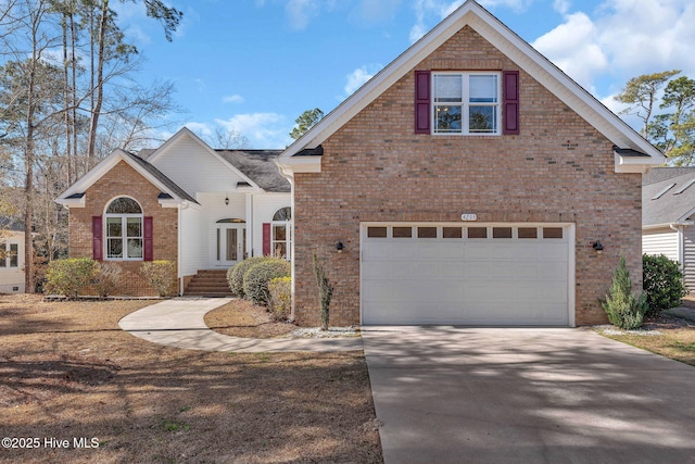 traditional-style home featuring driveway, an attached garage, and brick siding