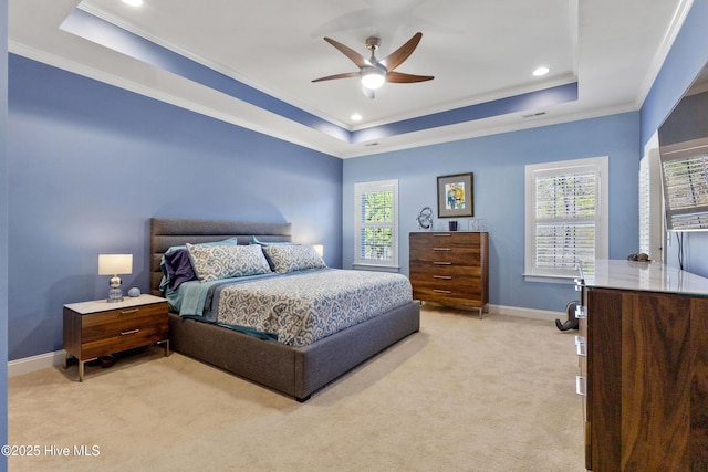 carpeted bedroom featuring crown molding, ceiling fan, and a raised ceiling