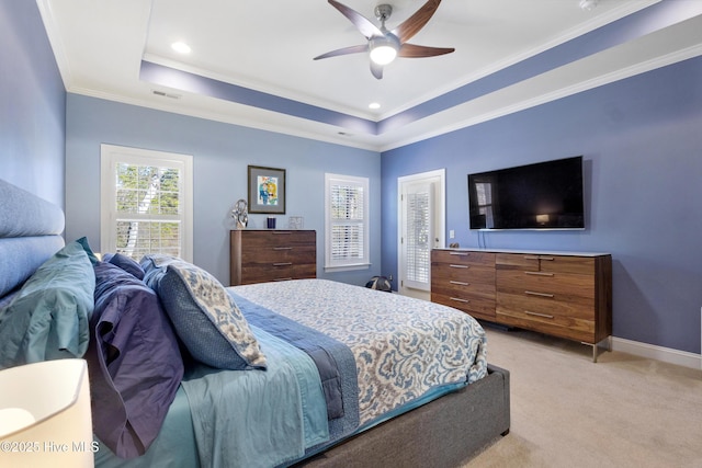 carpeted bedroom with a raised ceiling, ceiling fan, and crown molding