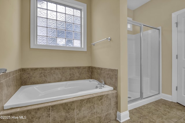 bathroom featuring a stall shower, a bath, and tile patterned floors