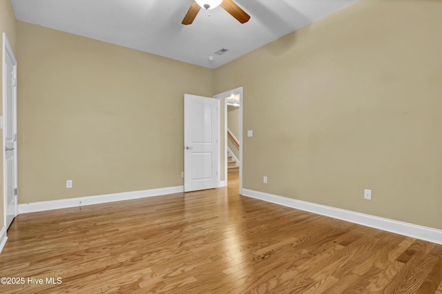 spare room with visible vents, a ceiling fan, light wood-style flooring, and baseboards