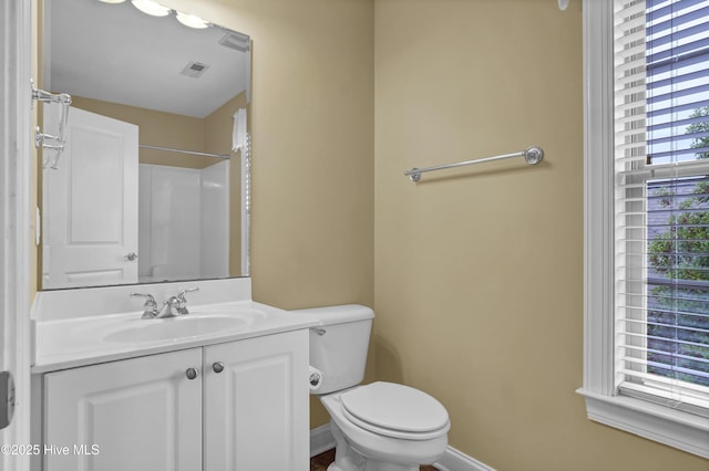 bathroom with baseboards, visible vents, toilet, walk in shower, and vanity