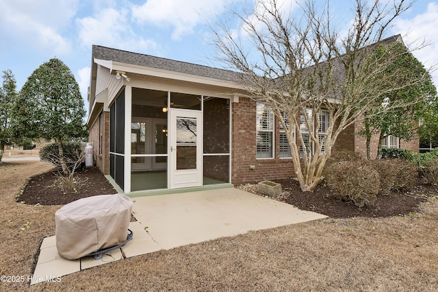 property entrance featuring a patio area and brick siding