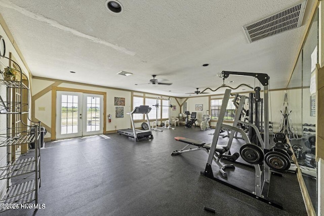 exercise room featuring a wealth of natural light, visible vents, a textured ceiling, and french doors