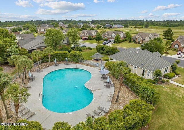 pool featuring a patio, fence, and a residential view