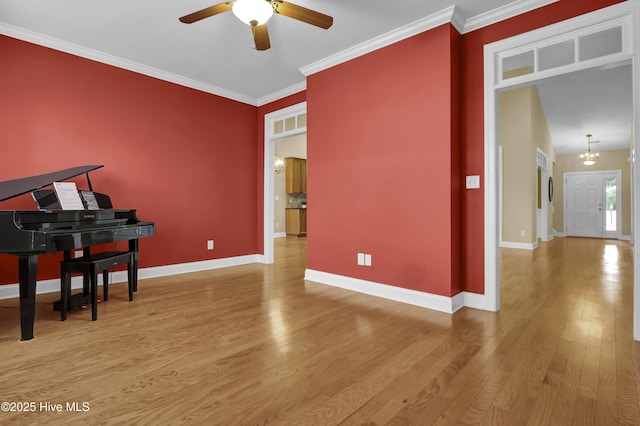 interior space with crown molding, baseboards, and wood finished floors