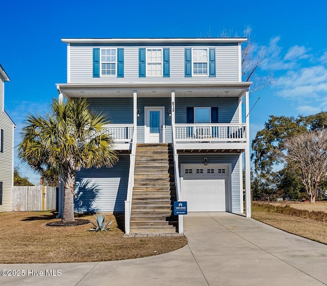 raised beach house with a porch, a garage, and a front lawn