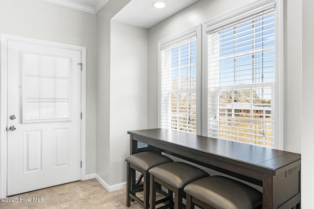 dining area featuring crown molding and light tile patterned flooring