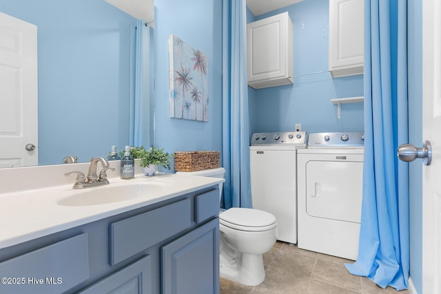 bathroom featuring vanity, tile patterned floors, washing machine and dryer, and toilet