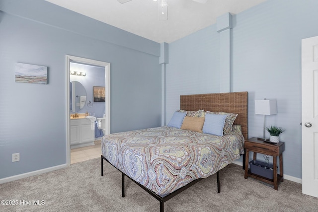 bedroom featuring ensuite bath and light colored carpet