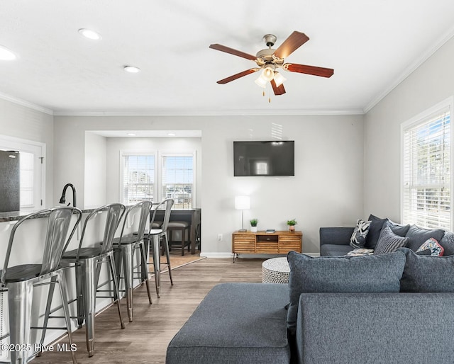 living room with crown molding, hardwood / wood-style flooring, a wealth of natural light, and ceiling fan