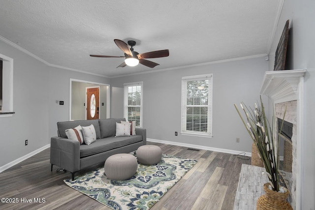 living room featuring dark wood-type flooring, ceiling fan, ornamental molding, and a textured ceiling