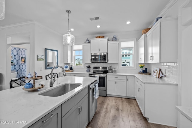 kitchen featuring appliances with stainless steel finishes, a sink, visible vents, and white cabinetry