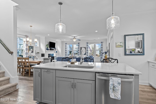 kitchen featuring a sink, open floor plan, light countertops, gray cabinets, and dishwasher