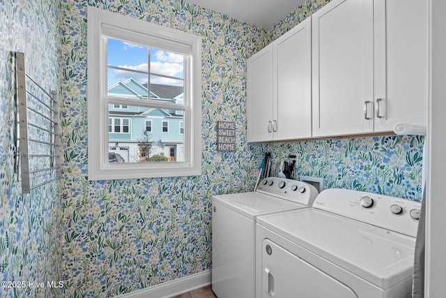 laundry area featuring baseboards, washer and clothes dryer, cabinet space, and wallpapered walls