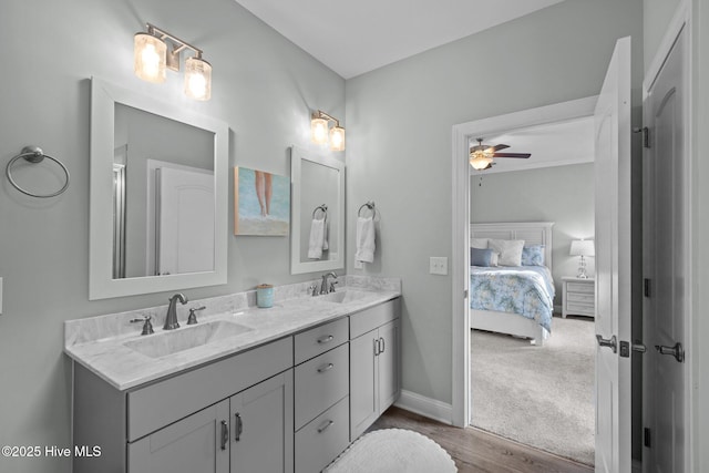 full bathroom with double vanity, a ceiling fan, a sink, and ensuite bathroom