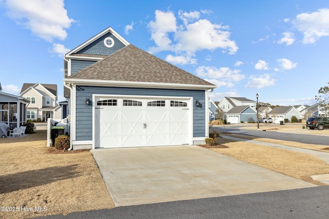 exterior space with a garage, driveway, a shingled roof, and a residential view