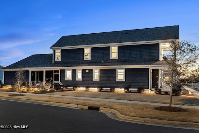 view of front of house with a shingled roof and a front yard