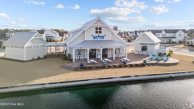 back of house with a patio area, a water view, and a residential view