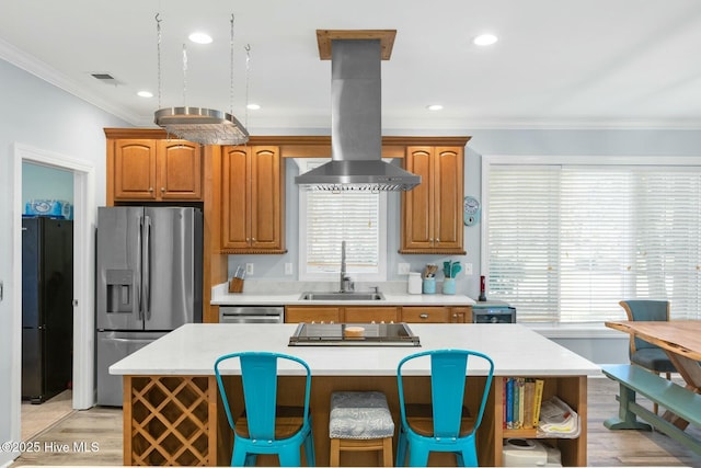 kitchen with sink, island range hood, a center island, ornamental molding, and black appliances