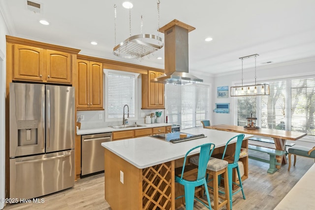 kitchen with a center island, crown molding, appliances with stainless steel finishes, island exhaust hood, and a sink